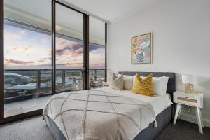 雪梨的住宿－The Sky Garden，一间卧室设有一张大床和一个大窗户