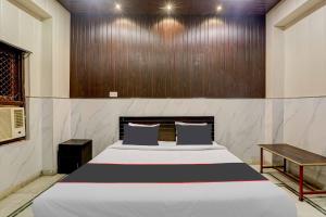a bedroom with a large bed and a wooden wall at OYO Flagship Hotel Tri Palace in Kānpur