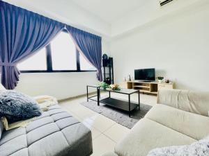 een woonkamer met een bank en een tv bij Kota Damansara 3BR for 1-12pax near IVF in Encorp in Petaling Jaya