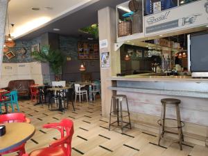 un restaurante con mesas y sillas y un bar en Oasis Backpackers' Toledo en Toledo