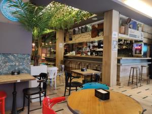 a restaurant with tables and chairs and a bar at Oasis Backpackers' Toledo in Toledo