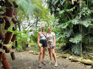 Luminosa Uvita Hostel في أوفيتا: سيدتان واقفتان بجانب بعضهما في غابة