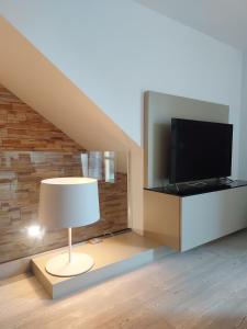 ein Wohnzimmer mit einer Lampe und einem TV in der Unterkunft Il Melograno in Toscana in Castelfranco di Sopra