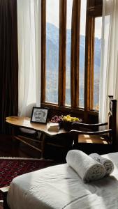 a room with a desk and a table with a view at Old Hunza inn in Hunza Valley