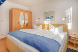 バンシンにあるApartment Seemöweのベッドルーム1室(大型ベッド1台、青い毛布付)