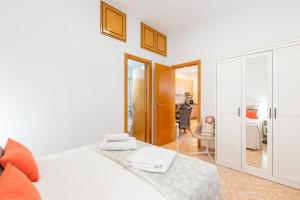 a bedroom with a white bed and a living room at WintowinRentals Great Apartment, Amazing Location in Parque Mediterráneo in Málaga