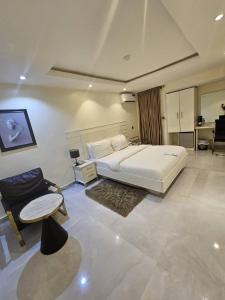 a bedroom with a large white bed and a couch at LUXOL HOMES&SUITES in Ikeja