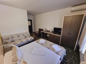 a hotel room with a bed and a desk at Vila Pretty Woman in Eforie Nord