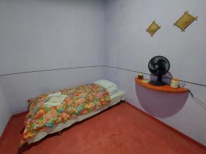 - une petite chambre avec un lit et un ventilateur dans l'établissement Pousada Naturaly, à Serra Caiada