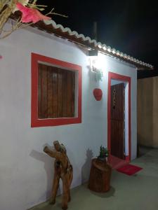 Cette chambre est dotée d'un mur blanc et d'une porte rouge. dans l'établissement Pousada Naturaly, à Serra Caiada