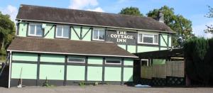 a building with a sign that reads the superior inn at The Cottage Inn in Llandeilo