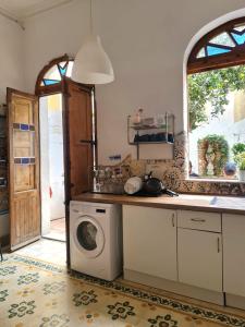 eine Küche mit einer Waschmaschine und einem Fenster in der Unterkunft Hostel On in Sliema
