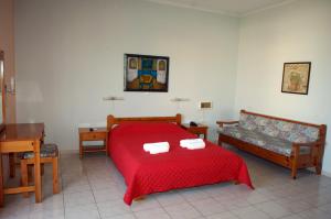 a bedroom with a red bed and a couch at Sunrise Hotel in Agia Ermioni +30 photos
