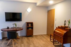 a living room with a table and a tv on the wall at Amtsgerichts Blick in Oppenheim