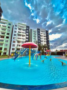 einen Pool mit einem Wasserpark mit Sonnenschirm in der Unterkunft P3 Cozy Stay / Waterpark / 7-8pax Ipoh in Ipoh