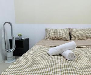 uma cama com duas toalhas em cima em P3 Cozy Stay / Waterpark / 7-8pax Ipoh em Ipoh