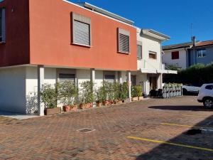 un edificio blanco y naranja en una calle de ladrillo en Hotel Mezzaluna, en Treviso