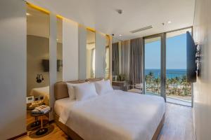 a bedroom with a bed with a view of the ocean at Taiyo Hotel & Apartment in Danang