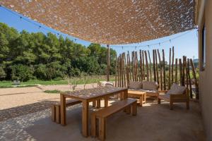 eine Terrasse mit einem Tisch und Stühlen unter einem Zelt in der Unterkunft Casa de campo Masos de Pals con parking y piscina in Pals