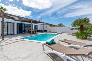 a villa with a swimming pool and lounge chairs at Villa Valentina Private Pool Playa Blanca By PVL in Playa Blanca