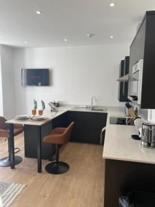 a kitchen with a table and chairs and a sink at Brand NEW apartment with FREE Parking, Sleeps 4, near Beach & City Centre in Waterloo