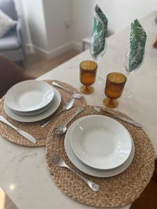 a table with plates and silverware on a table at Brand NEW apartment with FREE Parking, Sleeps 4, near Beach & City Centre in Waterloo