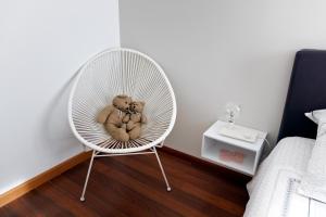 une chaise blanche avec des ours en peluche dessus dans une chambre dans l'établissement Grand appartement T2, lumineux, au calme, au pied des Calanques, proche Mer, à Marseille