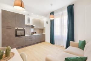 ein Wohnzimmer mit einem Sofa und einer Küche in der Unterkunft AlbaDea Apartment in Rom