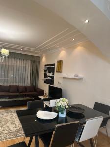 ein Wohnzimmer mit einem schwarzen Tisch und Stühlen in der Unterkunft 4-х комнатная квартира in Astana