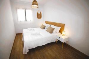 een slaapkamer met een groot wit bed en een tafel bij Blue Sand Apartment in Costa Teguise in Costa Teguise