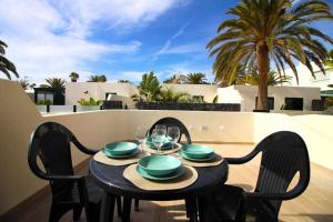 een tafel met borden en glazen op een balkon bij Blue Sand Apartment in Costa Teguise in Costa Teguise