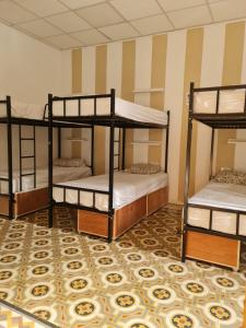 three bunk beds in a room with a carpet at Hostel On in Sliema