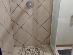 ducha con cortina y suelo de ducha en Kalahari Kaja en Kuruman