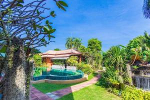 a house with a swimming pool and a garden at Monaburi Boutique Resort in Rawai Beach