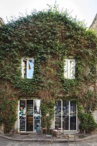 a building covered in ivy with windows and chairs at La Casetta a Monti in Rome