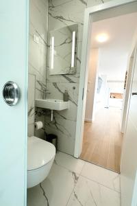 La salle de bains blanche est pourvue de toilettes et d'un lavabo. dans l'établissement Ivanečka 505, à Zagreb