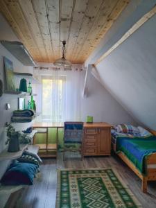 a bedroom with a bed and a desk and a table at Siedlisko Otulenie in Bartoszyce