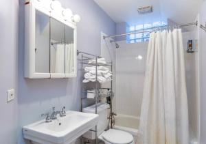 a bathroom with a sink and a toilet and a shower at Elegant 3 Bed One Bath At West Side in New York