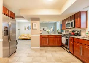 a large kitchen with wooden cabinets and stainless steel appliances at Elegant 3 Bed One Bath At West Side in New York