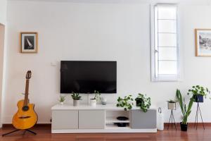 - un salon avec un centre de divertissement blanc et une télévision à écran plat dans l'établissement Grand appartement T2, lumineux, au calme, au pied des Calanques, proche Mer, à Marseille