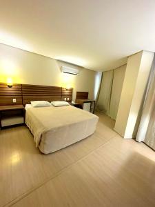 a bedroom with a large white bed in a room at Umbu Hotel Porto Alegre - Centro Histórico - Prox Aeroporto 15min in Porto Alegre