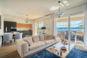 un soggiorno con divano bianco e una cucina di Livingstone Beach House a Trogir