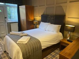 a hotel room with a bed with towels on it at Glazert Country House Hotel in Lennoxtown