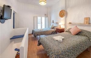 Zimmer mit 2 Betten und einem TV an der Wand in der Unterkunft Gorgeous Home In El Gastor With Kitchenette in El Gastor