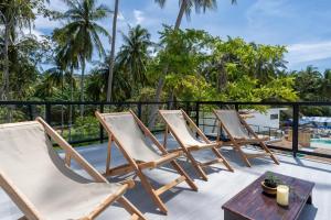 a row of chairs on a patio with a table at Manao Seaview Pool Villa 44 - 5 Mins Walk To The Beach in Ko Lanta