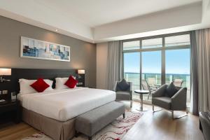 Ramada by Wyndham Dubai Barsha Heights في دبي: غرفة فندقية بسرير ونافذة كبيرة