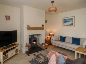 a living room with a couch and a fire place at Charlotte's Cottage in Seahouses