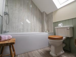 a bathroom with a toilet and a bath tub at Charlotte's Cottage in Seahouses