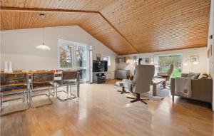 un soggiorno con soffitto in legno, tavolo e sedie. di Lovely Home In Hurup Thy With Wifi a Sønder Ydby