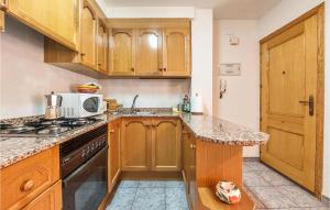 a kitchen with wooden cabinets and a counter top at 2 Bedroom Nice Apartment In Moncofa in Moncófar